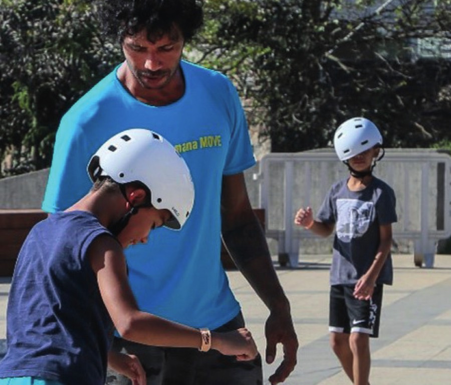 Educador ajudando crianças com capacete na Casinha do Skate
