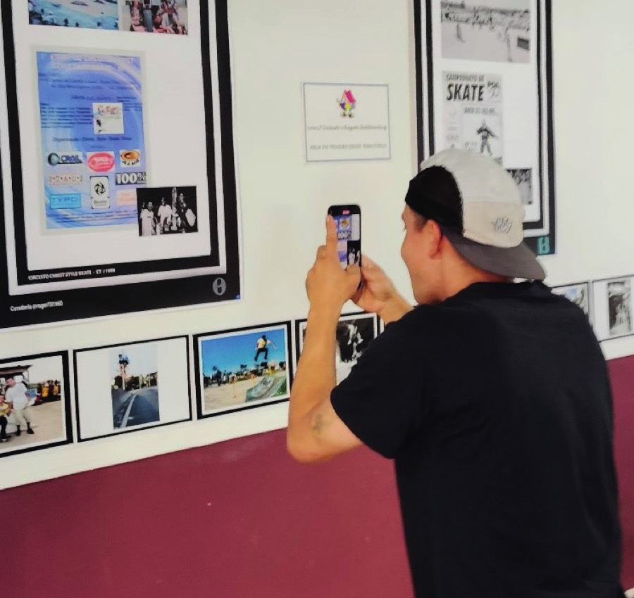 Criança fotografando mural de recortes na Casinha do Skate