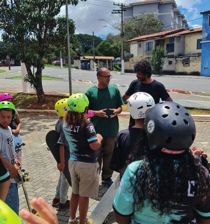 Crianças com capacetes e skates em atividade