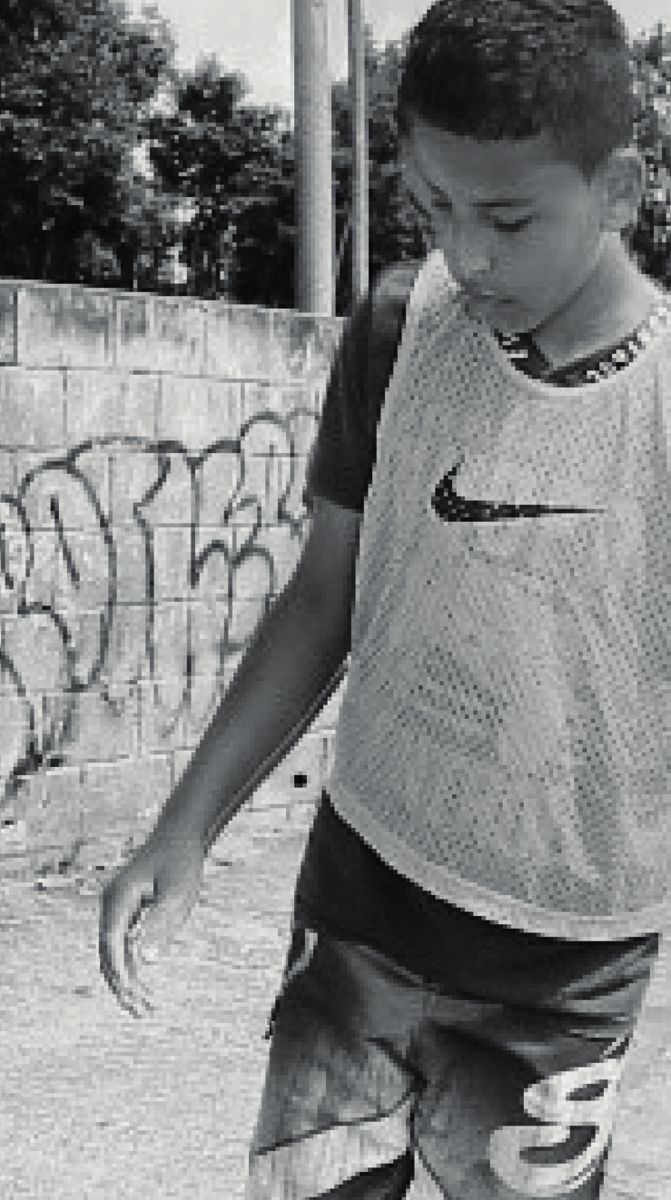 Criança com skate em preto e branco