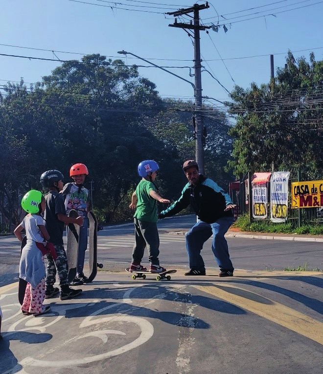 Crianças aprendendo skate na rua do bairro